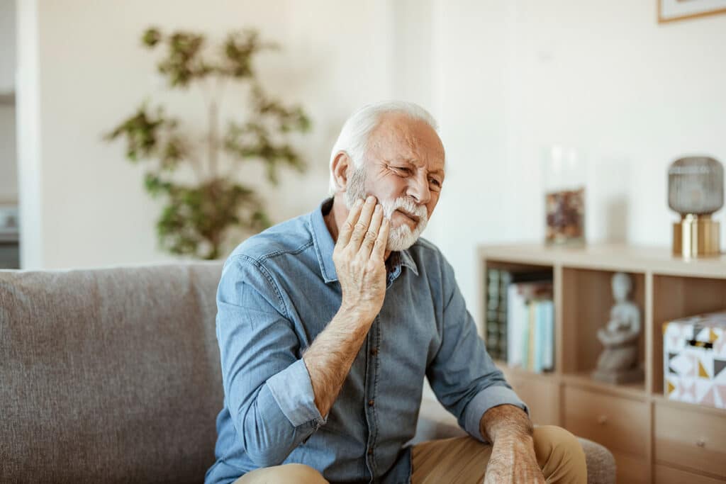 Man holding mouth in pain